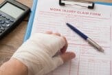 Injured hand with medical paperwor